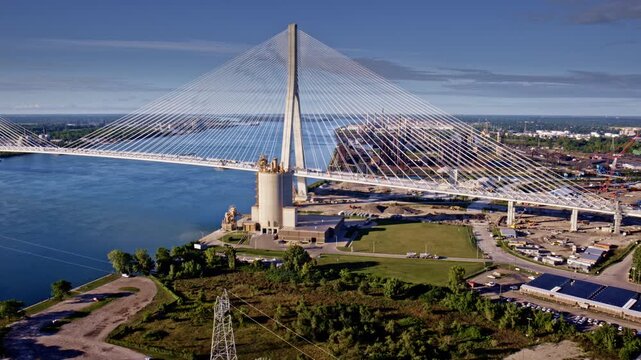 Aerial view of the new Gordie Howe International Bridge heading toward the industrial zone by the Detroit River.
