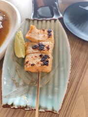Grilled salmon belly with salt and lemon wedges