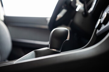 Fototapeta premium New car automatic gearbox lever and knob. Close up shot, low angle, side view, no people