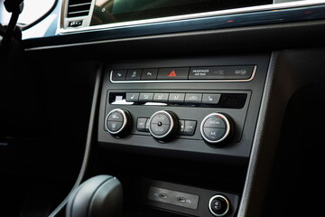New car climate control panel with plastic knobs, buttons and dials. Close up shot, no people