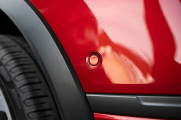 New car fender or bumper mounted, round parking sensor. Close up, detail shot, no people