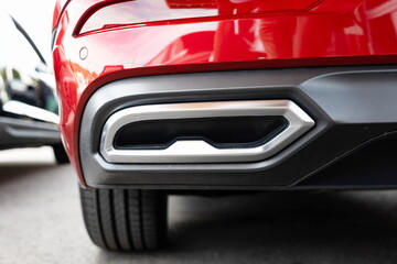 Twin tip car exhaust pipe tip chrome bumper decoration on a new European car. Close up shot, no people