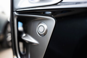 New car fender or bumper mounted, round parking sensor. Close up, detail shot, no people