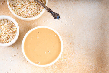 Tahini with sesame seeds, oily sesame paste, source of healthy fats, snack or ingredient in Middle...