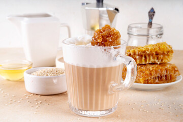 Tasty sweet and salted tahini honeycomb latte. Hot coffee drink with whipped non-dairy creamer, tahini sesame paste, honey and honeycomb garnish
