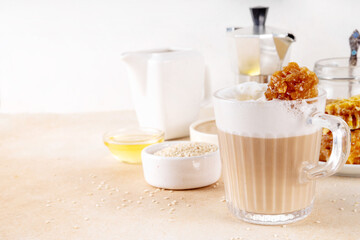 Tasty sweet and salted tahini honeycomb latte. Hot coffee drink with whipped non-dairy creamer,...