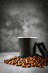 Coffee in papercup and coffee beans on gray background, aroma paper coffee cups aromatic