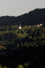 A Serene Hillside Village Featuring a Beautiful White Church at Dusk