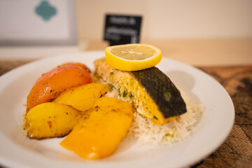 Delicious gourmet dish with grilled salmon fillet served with sweet potatoes and steamed rice, beautifully plated on a white ceramic dish