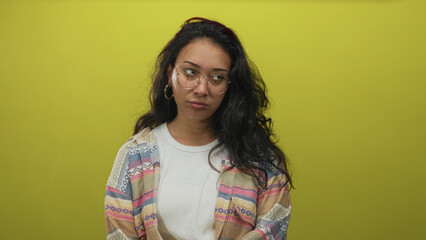 Fototapeta premium Woman wearing patterned shirt with visible face and closed eyes and pursed lips making a smirk in a lime green studio; skepticism contemplation.