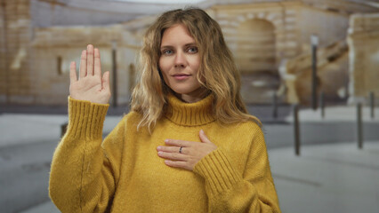 Woman lifts hand in a swearing street portrait, her blonde young expression reflecting oath pledge...