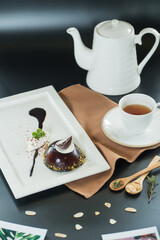 A refined tea time setting, featuring a delicate cake and warm tea, evoking moments of tranquility. A composition of a dessert with a cup of tea and a teapot