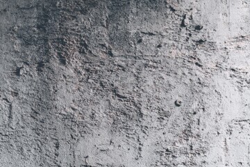 Fototapeta premium Textured gray concrete wall surface with rough patterns.