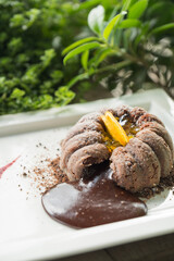 A close-up view of a chocolate dessert with oozing lava on the plate