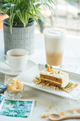 A delightful still life featuring carrot cake, tea, and a refreshing iced drink. A charming composition showcasing delectable treats