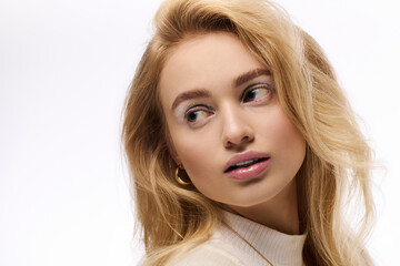Naklejka premium Beautiful young blonde woman in cozy knit outfit on a wintery backdrop