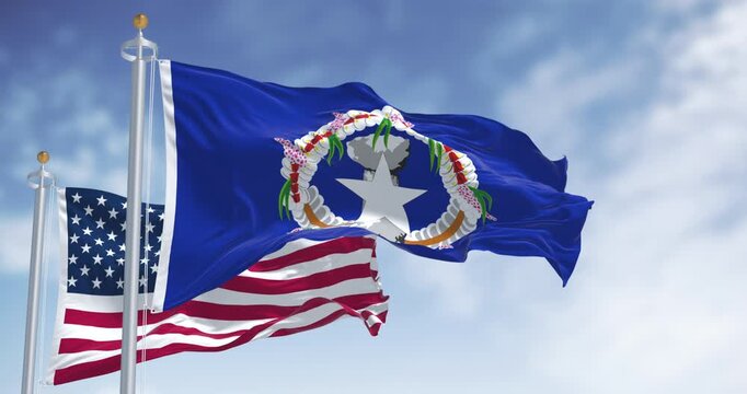Flags of Northern Mariana Islands waving in the wind with the US flag on a clear day