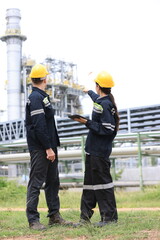 Engineers male, female working with tablet in industry oil refinery oil, gas refinery background,...