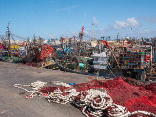 A Vibrant Scene of Fishing Boats and Nets at the Bustling Essaouira Port, Morocco, Under a Clear Blue Sky