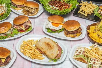 Asian composition with a teriyaki burger, spring rolls, and soy sauce on a bamboo background