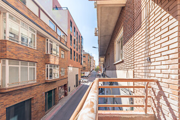 Residential building with a rustic brick facade and striped canvas roll-up awnings on each balcony