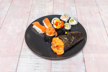 Marinated salmon uramaki with dill and cucumber, topped with sliced ​​salmon on porcelain