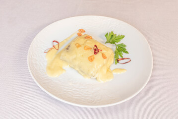 Creamy cod loin with a perfect emulsion of garlic and olive oil, presented in a clay pot over a low flame.