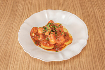 Cod with homemade tomato and black olives, slowly cooked in a cast-iron pot with Mediterranean herbs