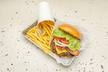 Gourmet burger with a sirloin and flank steak blend, melted Reblochon cheese, mountain tomato, and lettuce on a brioche bun