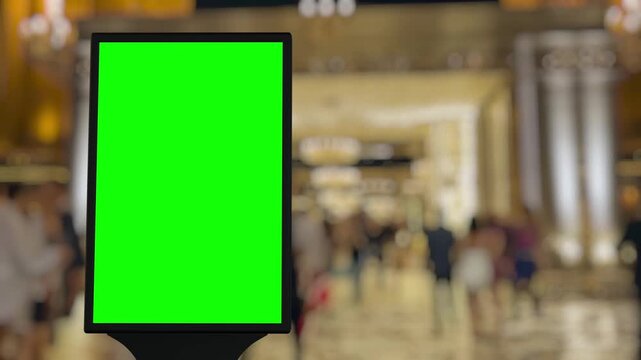 Timelapse of a vibrant shopping mall walkway features a centrally positioned green screen billboard, ideal for creative advertisement placement