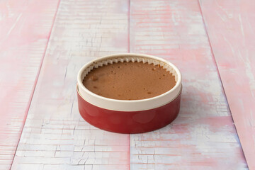 A triple chocolate cheesecake (white, milk, and dark) in perfectly defined layers, decorated with a swirl of cream and a strawberry