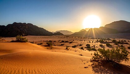 Desert landscape at dawn with sand dunes in the foreground. Sun beams radiate brightly over the distant mountains and sparse vegetation