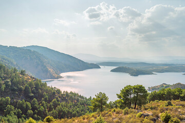 Summer view of the reservoir from the dam, covering the expanse of water and the mountains in the background on a clear day