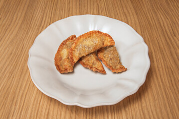 Spinach and raisin empanadas with pine nuts, thin and spiced dough, served with cane honey for a sweet and savory contrast.
