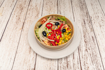 A Mediterranean salad with ripe plum tomatoes, feathered red onions, and purple oak leaf lettuce, tossed with  olive oil.