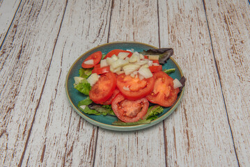 Colorful salad with green tomatoes  , finely diced sweet onions, and a mix of baby greens, dressed with Picual olive oil