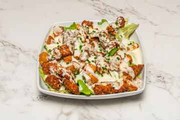 Homemade chicken salad with a bed of mesclun lettuce, cherry tomatoes, sweetcorn, diced cheddar cheese, and a creamy ranch dressing