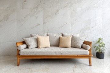 Fototapeta premium A modern wooden sofa with cushions rests against a marble-tiled wall.