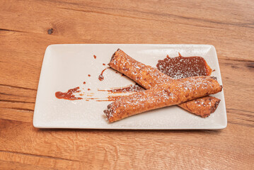 Chocolate crepes with an orange touch filled with ginger chocolate cream, decorated with candied citrus zest