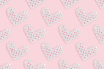 Pattern made from white hearts. Figurine made from acrylic beads on a pink background.