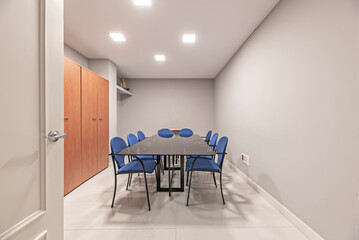 room with a large dark   table and high-backed chairs upholstered in blue fabric, cozy and functional