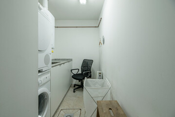 Laundry room with a top-loading washing machine, a compact boiler, and open shelves for cleaning products