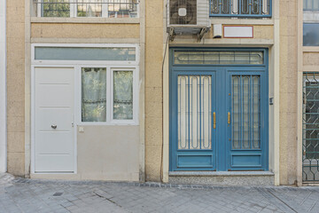 Urban loft facade with a folded metal door and a translucent glass panel that diffuses light into...