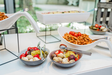 Professionelles Catering-Buffet mit Warmhaltebehältern und reichhaltiger Auswahl an Speisen auf einem festlichen Bankett