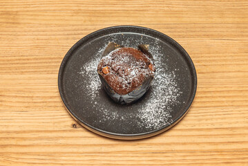 Almond and coconut muffins with toasted coconut flakes, presented on a contemporary china plate with a geometric design in neutral tones