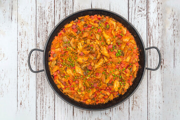 Duck paella with a red wine reduction, showcasing The juicy pieces of meat and the brilliant ric
