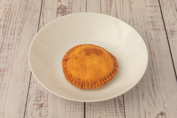 Tuna and bell pepper empanadas with chopped hard-boiled egg, homemade dough, and fresh parsley, presented in a wicker basket with absorbent paper