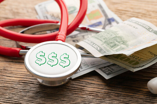 High cost of healthcare concept. Red stethoscope with 3, green, dollar signs on the diaphragm.