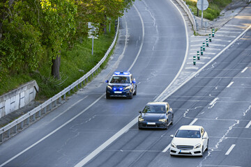 A local police patrol car issuing a warning with its hazard lights on the shoulder of the M-30 motorway in heavy traffic. © Toyakisfoto.photos