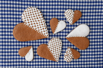 Decorated heart-shaped gingerbread cookies in three sizes on a checkered background